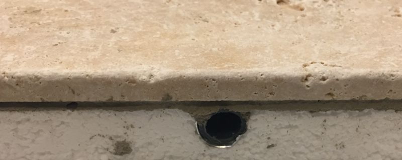 Vue en coupe d'un plancher rafraîchissant avec finition Travertin pour véranda