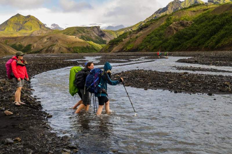 backpackers-crossing-water-in-iceland