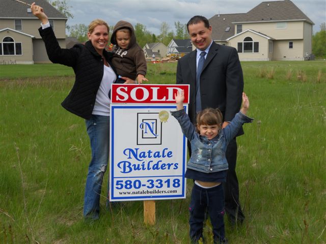 Linda in front of sold sign