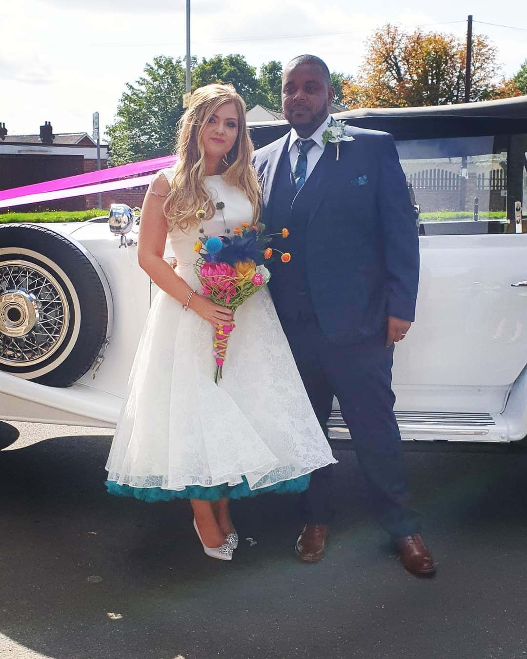 Bride and Groom next to their vintage car arriving at the church