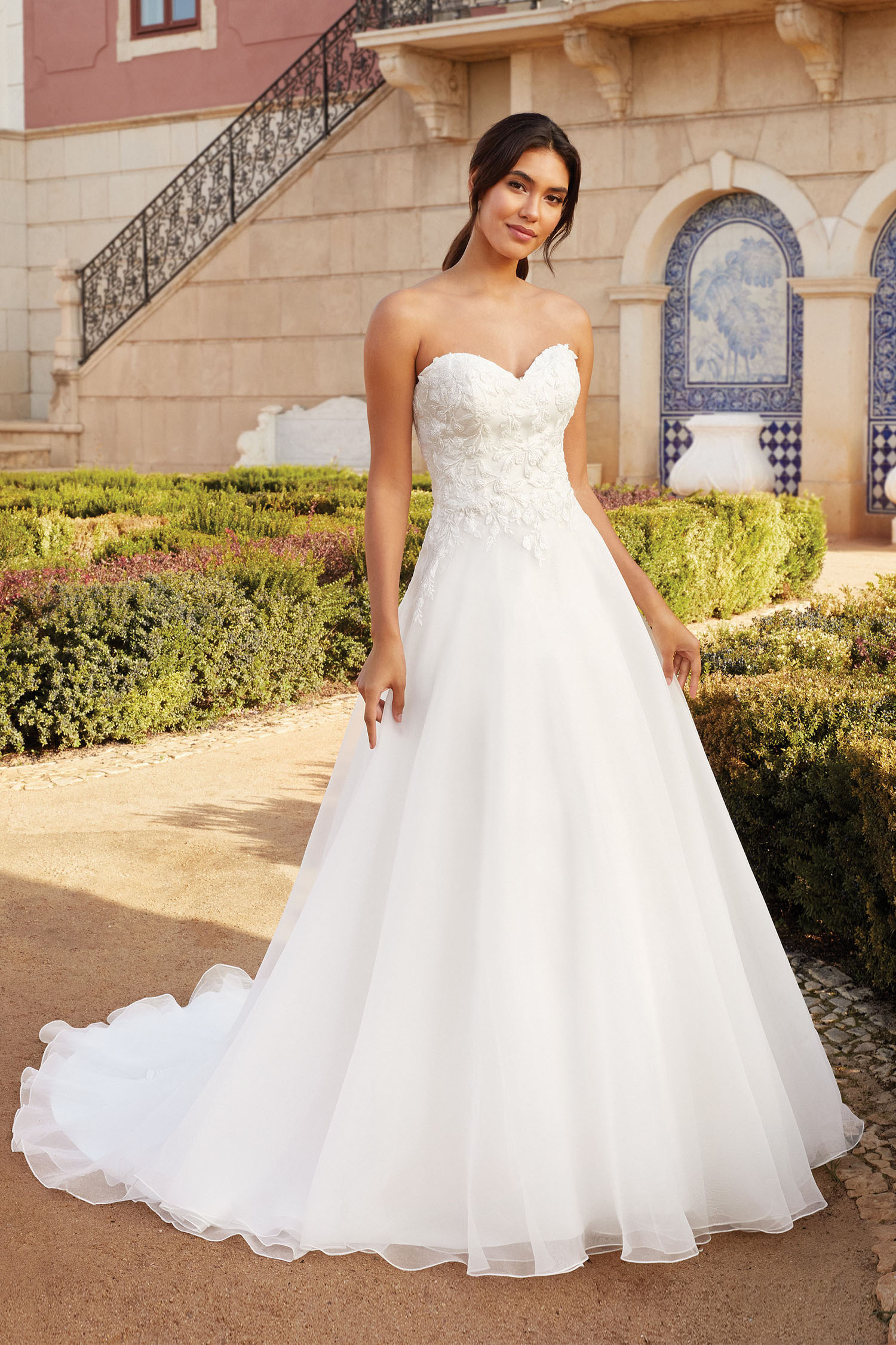 Bride wearing an Aline wedding gown with sweetheart neckline and beaded bodice over a full organza skirt.
