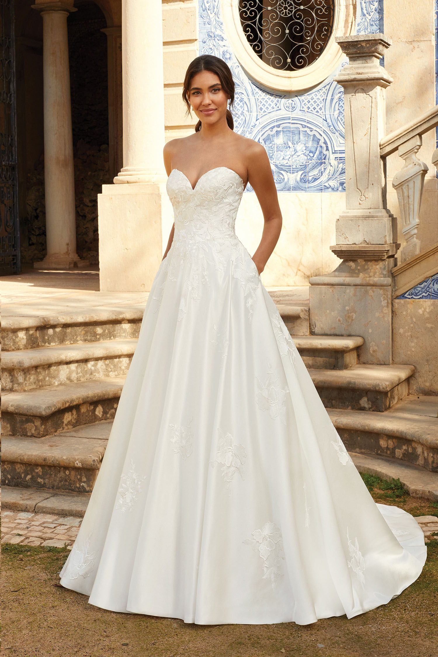 Bride wearing satin sweeheart style gown with pockets.