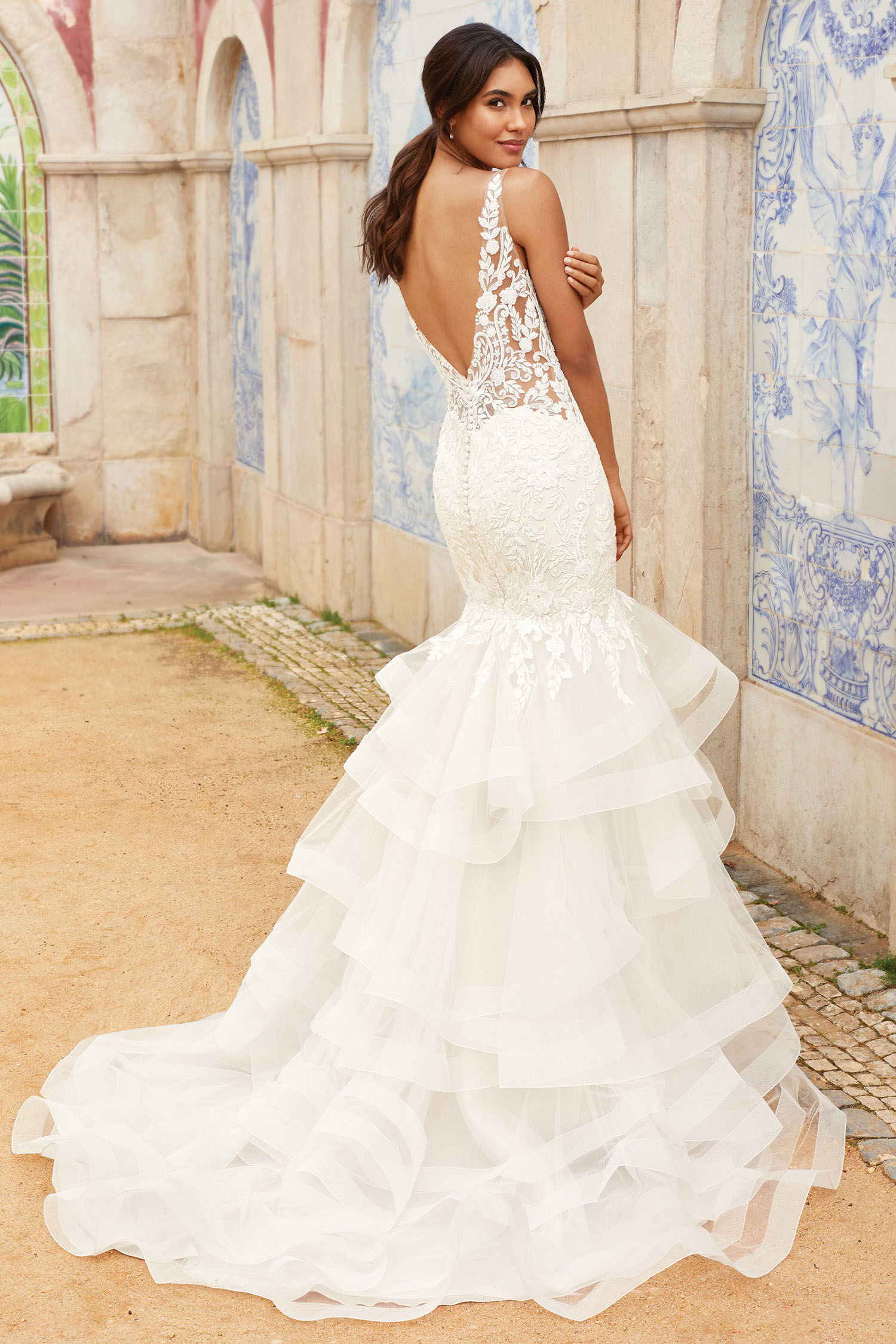 Bride wearing figure hugging fishtail gown with tiered skirt