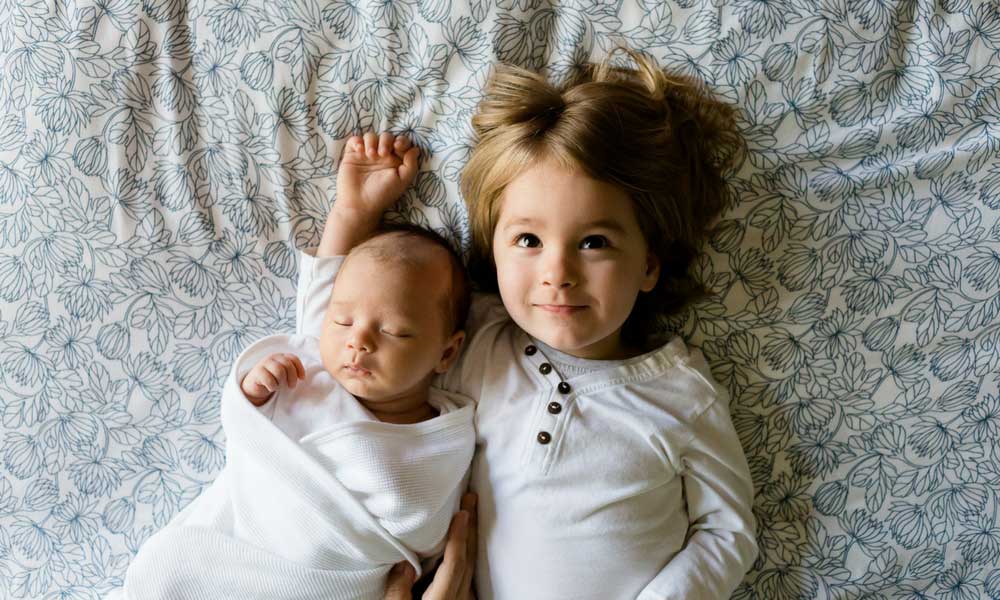 Daugher and baby lying in bed