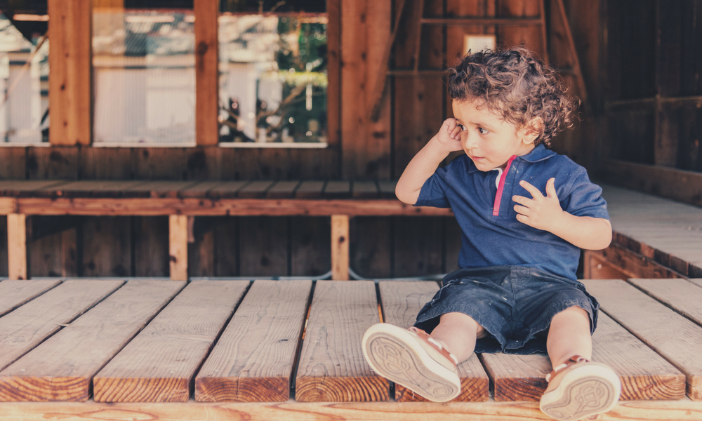 kid sitting in shade during summer