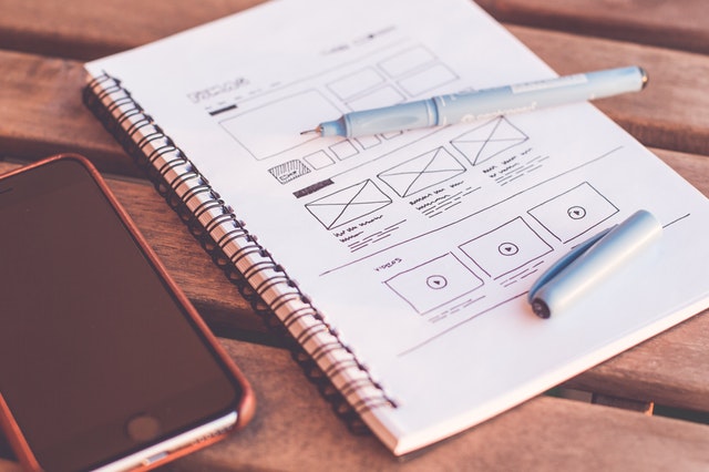 A notebook with website layouts sketched on its pages.