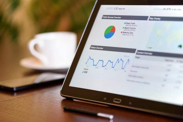 A tablet screen with charts and graphs of ad performance data.