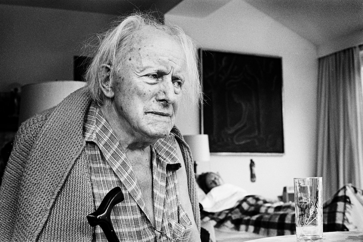 foto van Paul Delvaux, de bijna blinde kunstenaar met in de achtergrond zijn zieke geliefde in bed