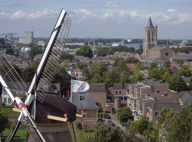 foto van bovenaf van een stad met molen, huizen en een kerk