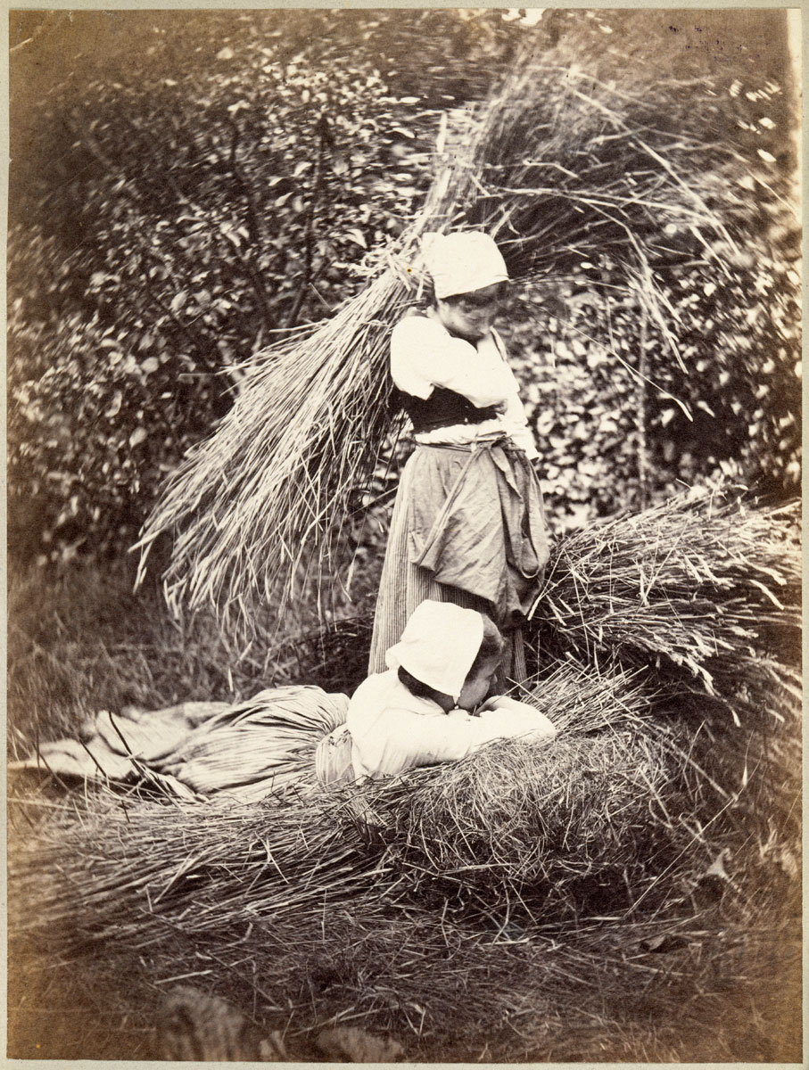 foto van twee boerinnen die hooi bijeenbinden in 1878