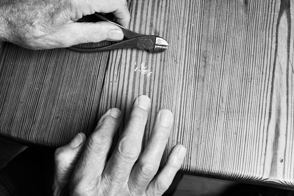 foto van handen met een tang op een stuk hout