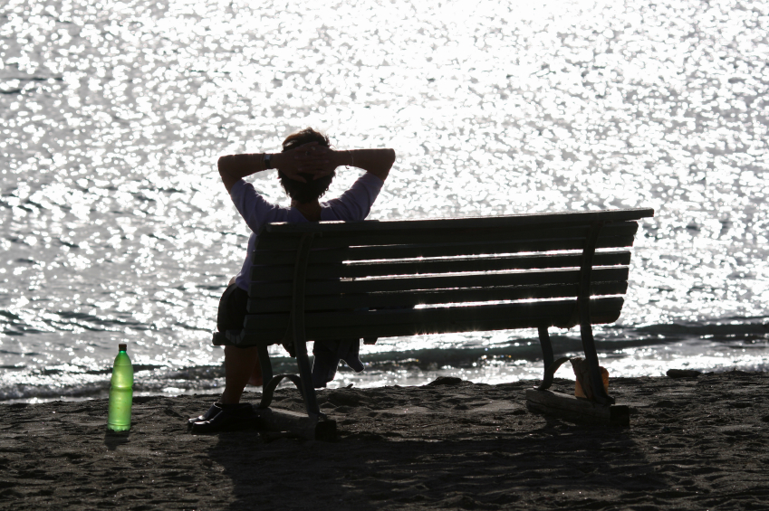 tegenlicht foto, vrouw op bank bij water reflectie en groene fles op de grond