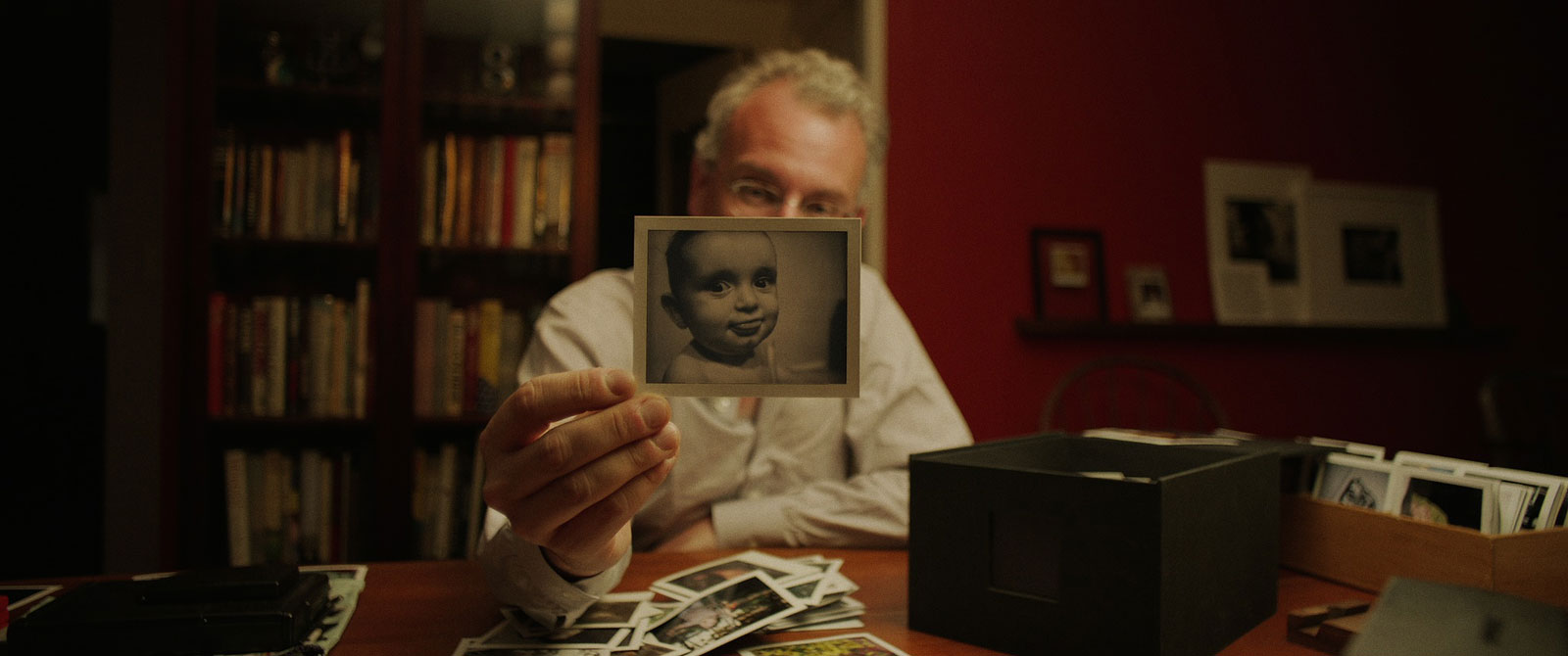 man met berg polaroids toont een polaroidfoto van baby