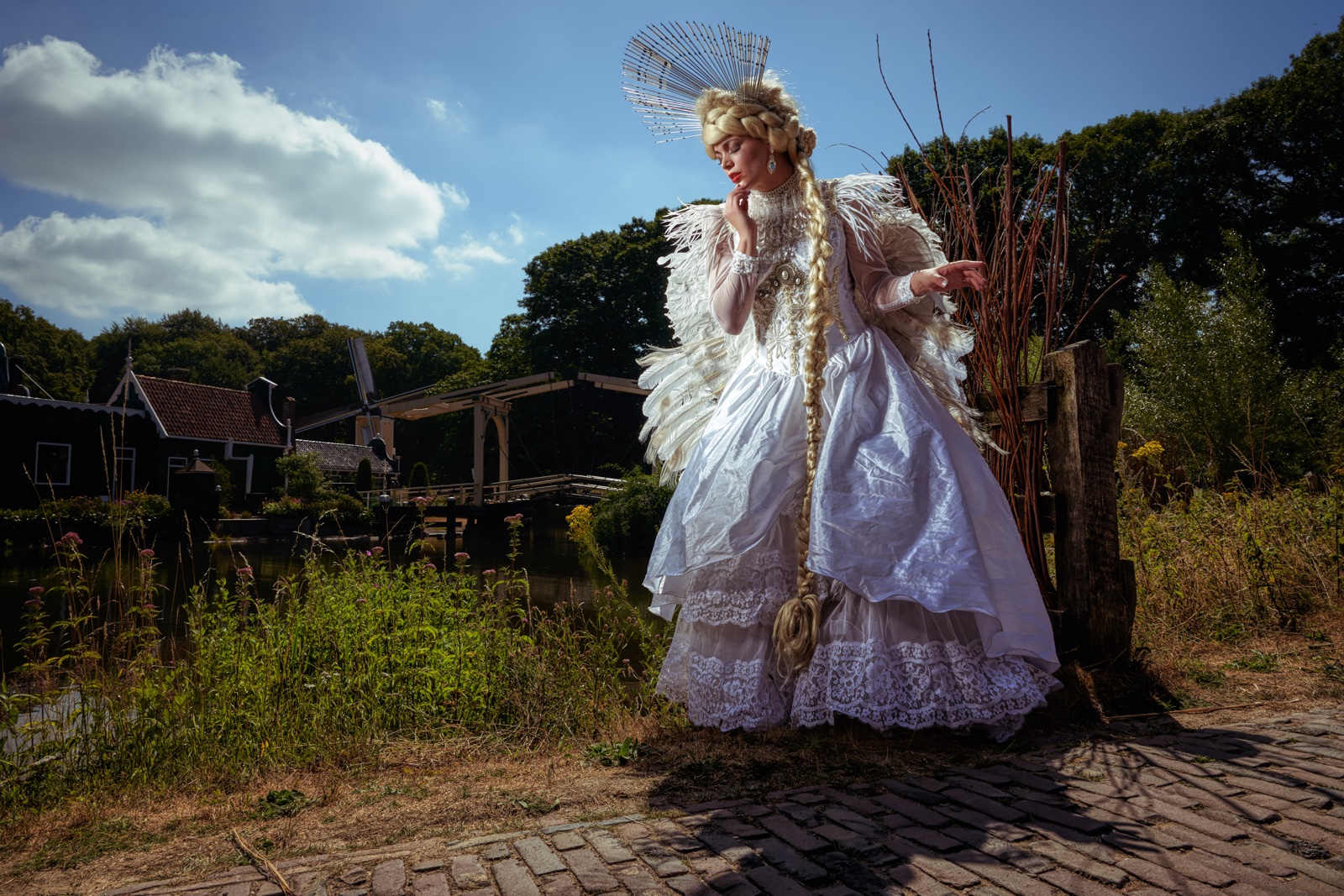 foto: © Frank Doorhof - model met witte jurk en veren op pad bij brug en huisjes