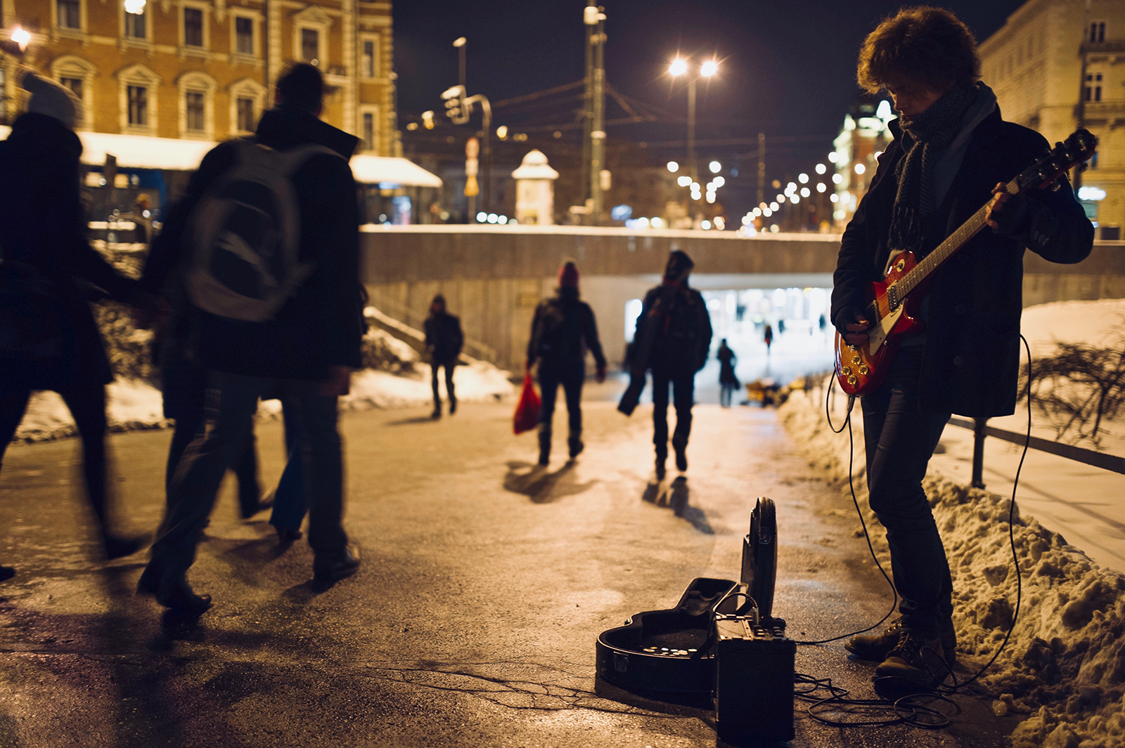 straat in stad met mensen en muzikant bij avond