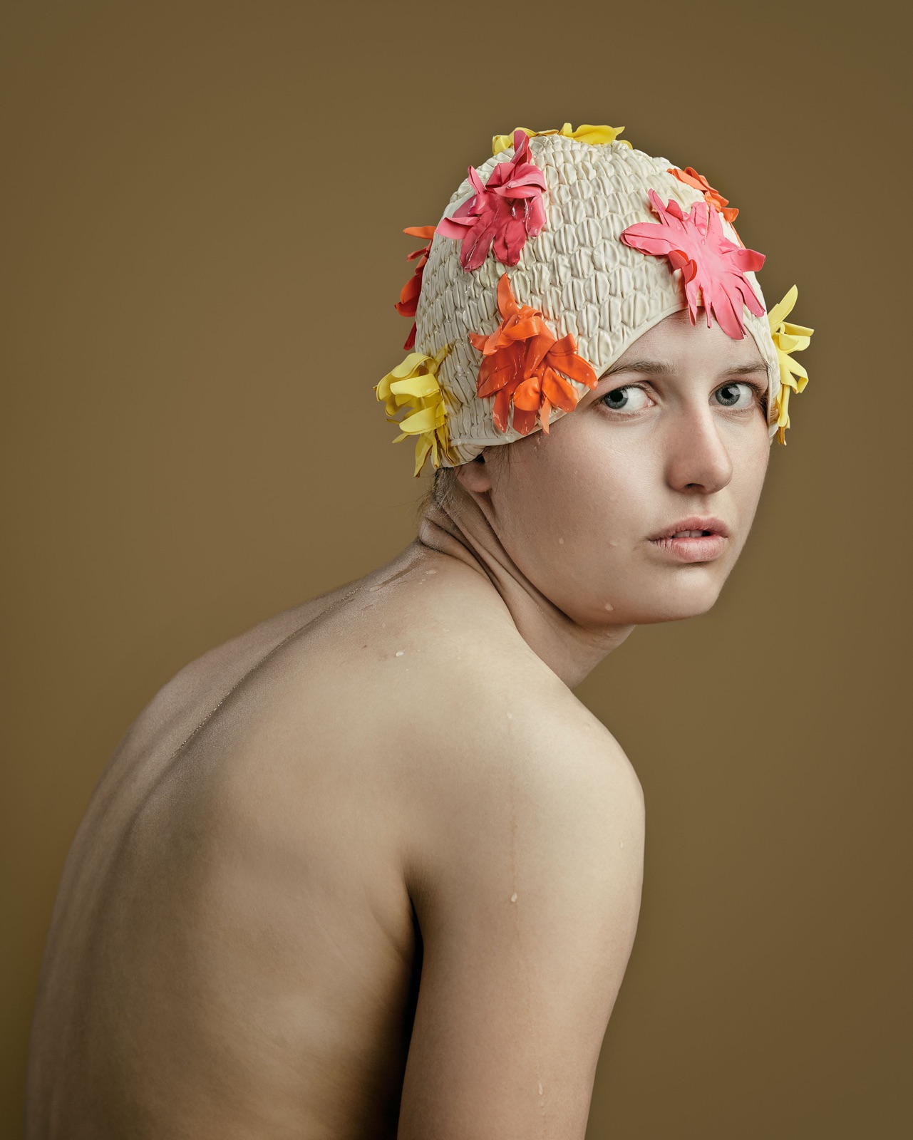 fotoportret van zwemster met badmuts op met roze oranje en gele bloemen