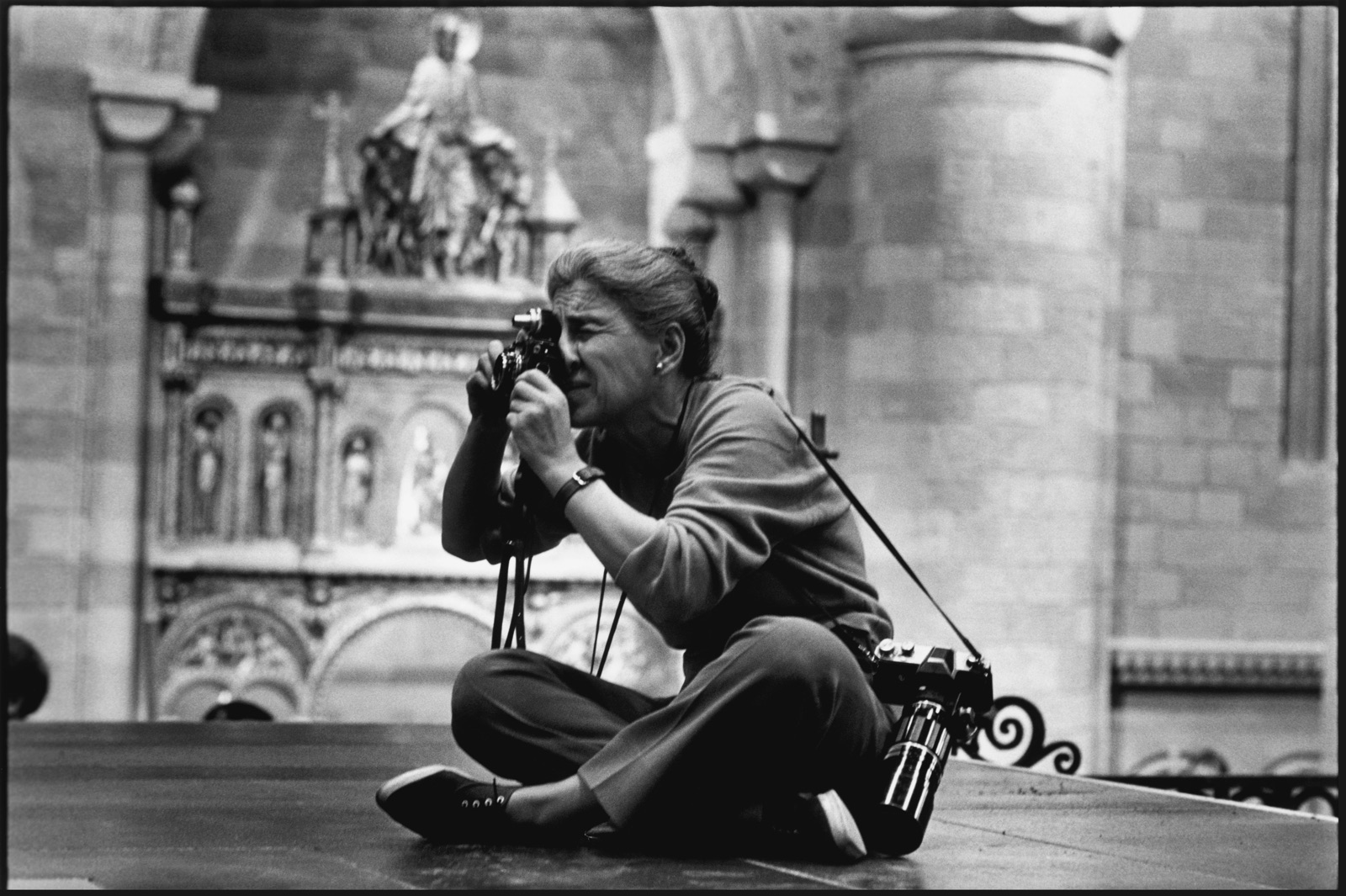 foto van Eve Arnold aan het fotograferen zittend op de grond