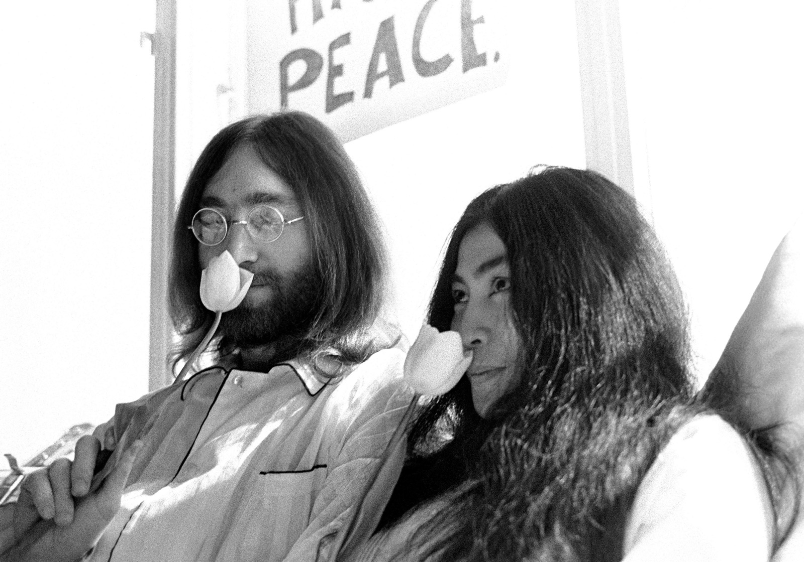 foto van John Lennon en zijn bruid Yoko Ono in bed in het Hilton Hotel ruikend aan een witte tulp