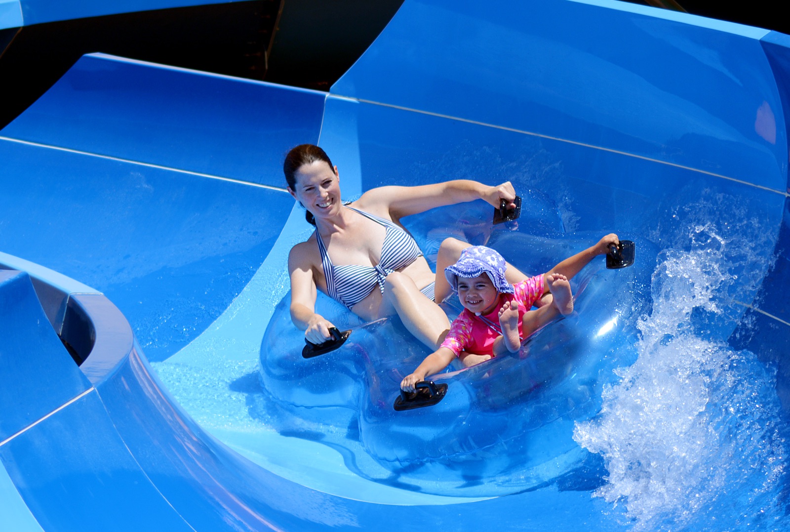 foto van moeder en zoon tje die van een waterglijbaan afkomen