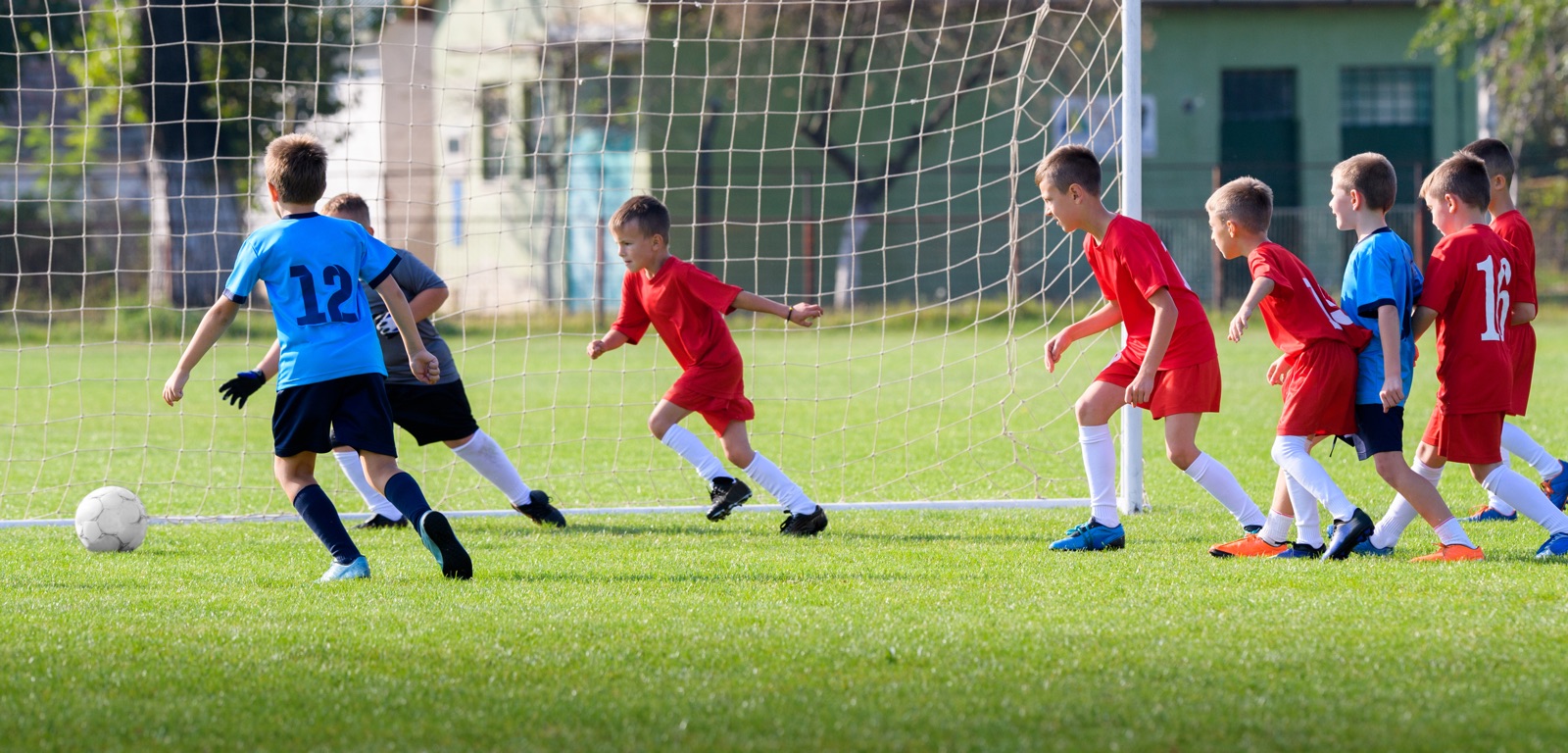 foto van een jong voetbalteam in actie bij doel