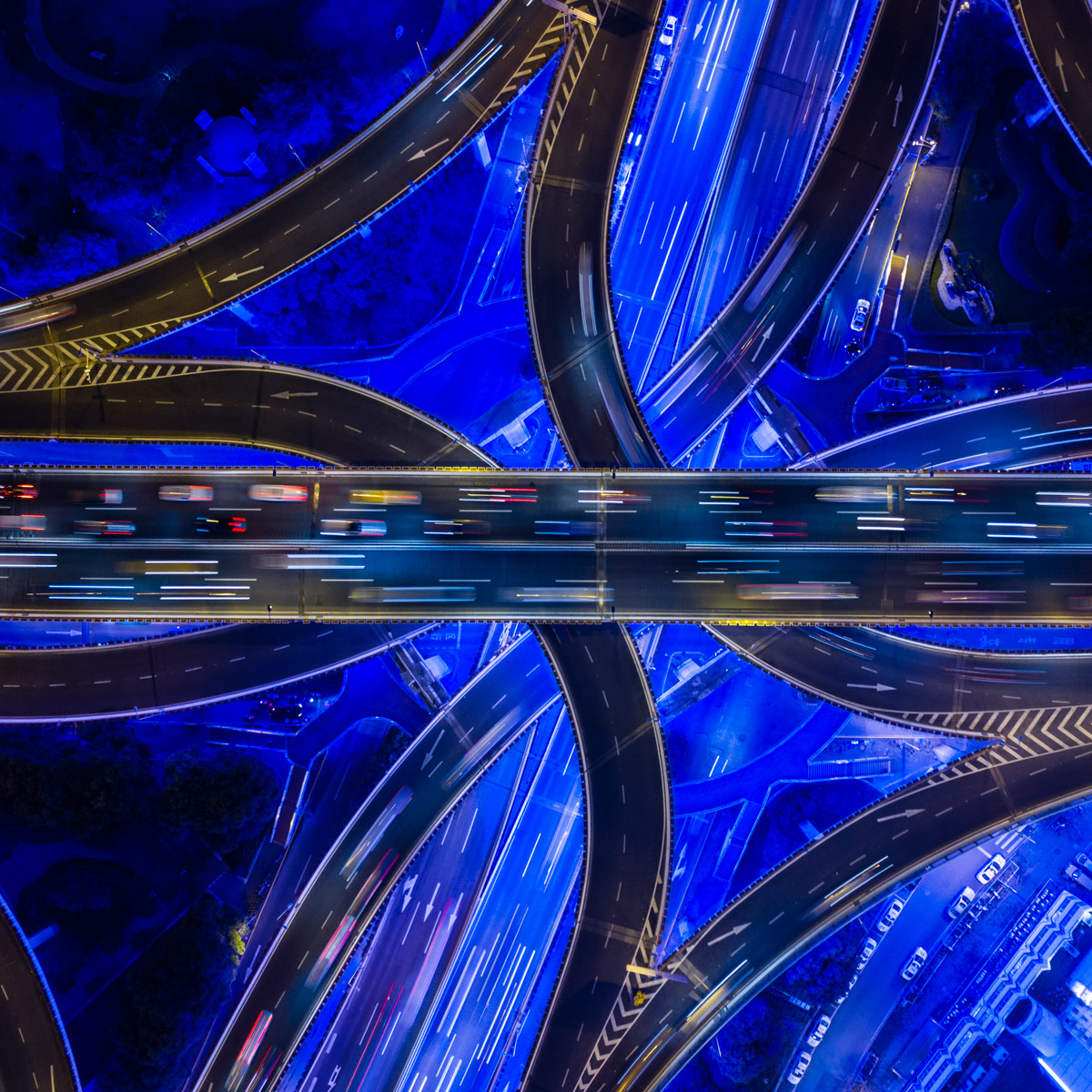 foto van bovenaf van een netwerk van snelwegen die over elkaar heen lopen in blauw