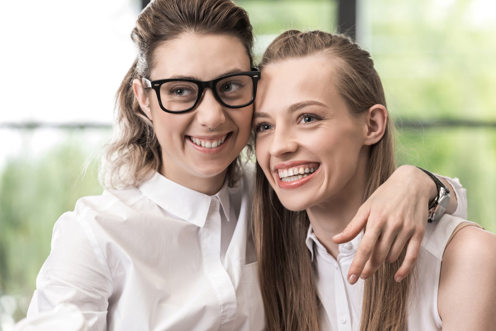 portret van twee meisjes lachend naar iets naast camera