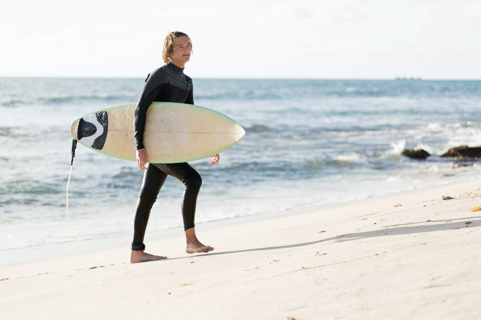 jonge man met surfplank bij de zee