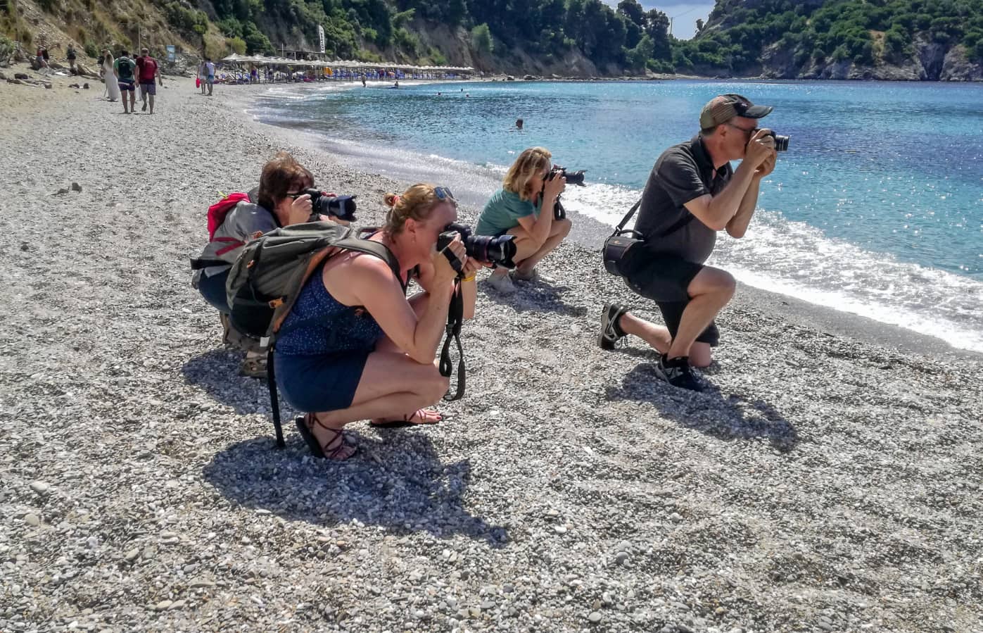 fotografen op Skopeloos, Griekenland op het strand bij de kustlijn