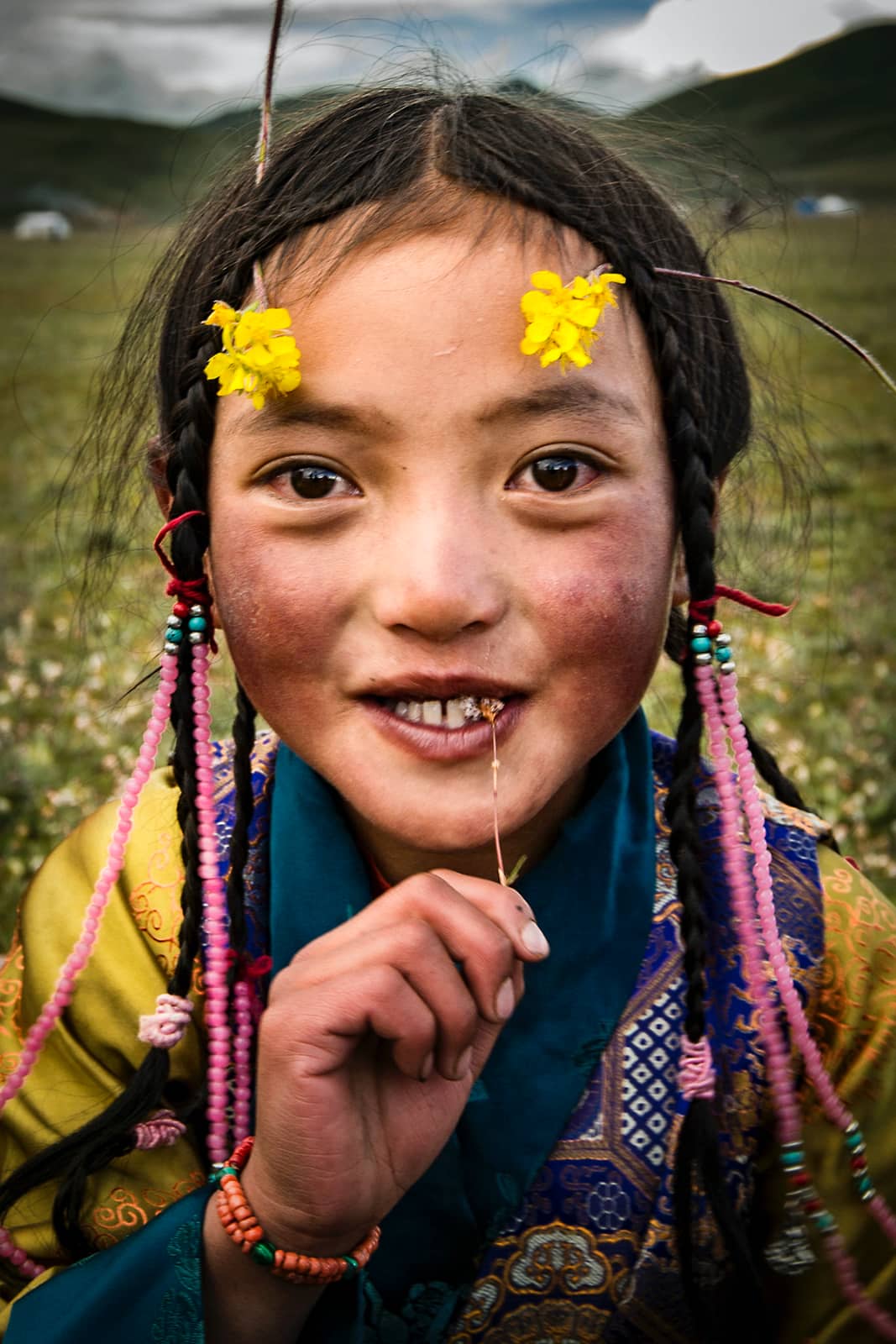 Portret van eskimo meisje met bloemetjes en vlechtje in haar in gebied met heuvels en wolken, Photographer: Zijie Gong, China