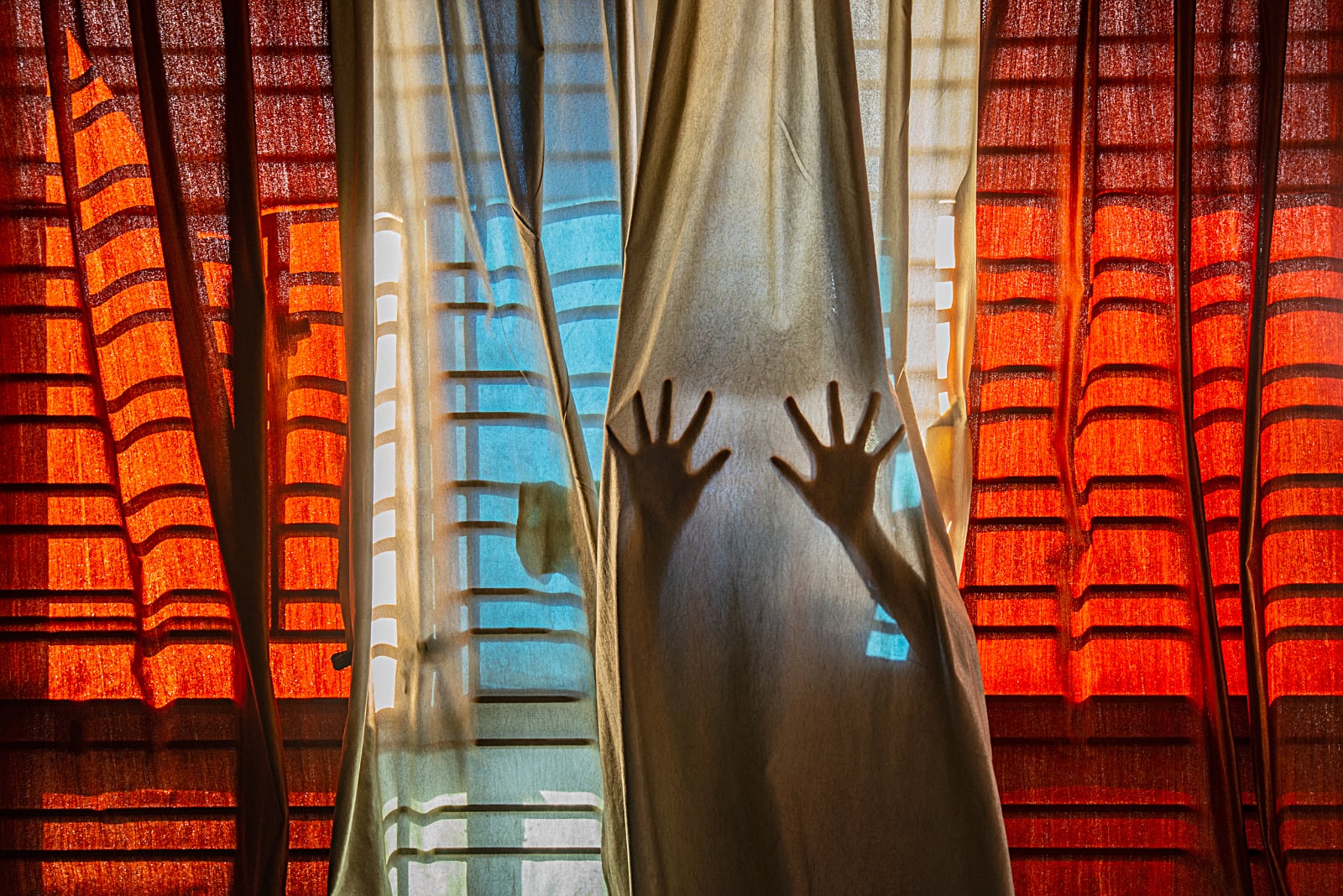 foto: © Pubarun Basu, India, Shortlist, Youth, Composition and Design, 2021 Sony World Photography Awards - Van achter de gordijnen probeert een paar handen door te breken,