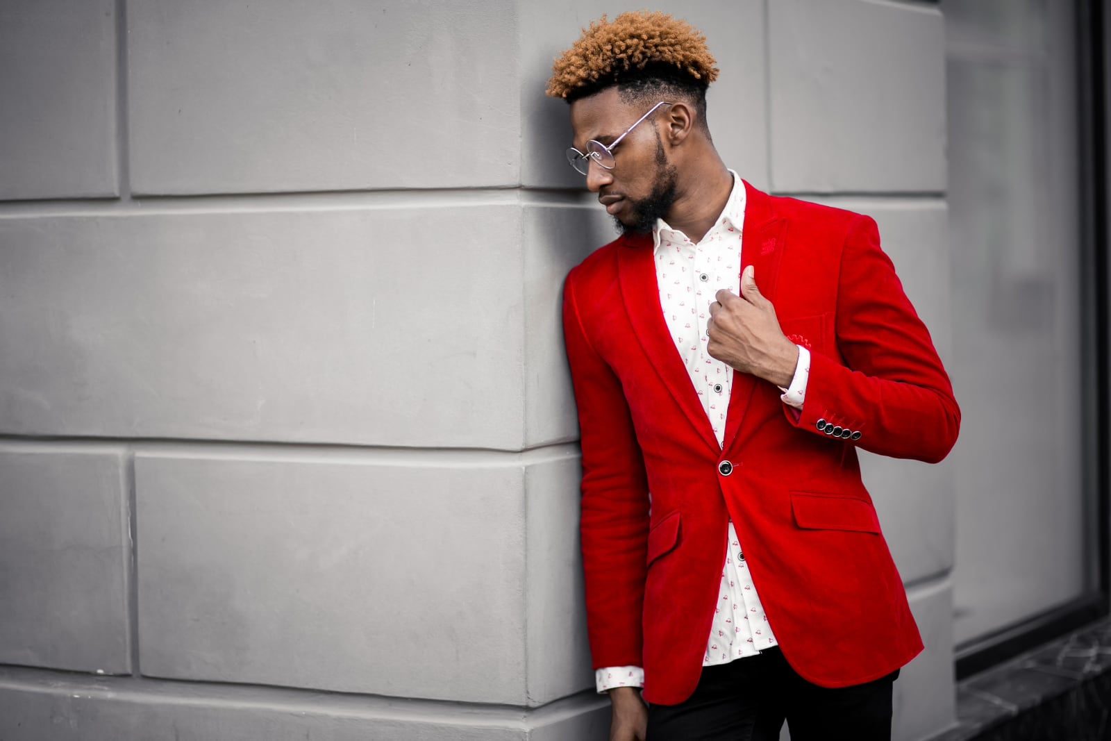 Voorbeeldfoto voor fotowedstrijd ROOD op Fotografie.nl, een man met rood colbert leunt tegen een mooie muur