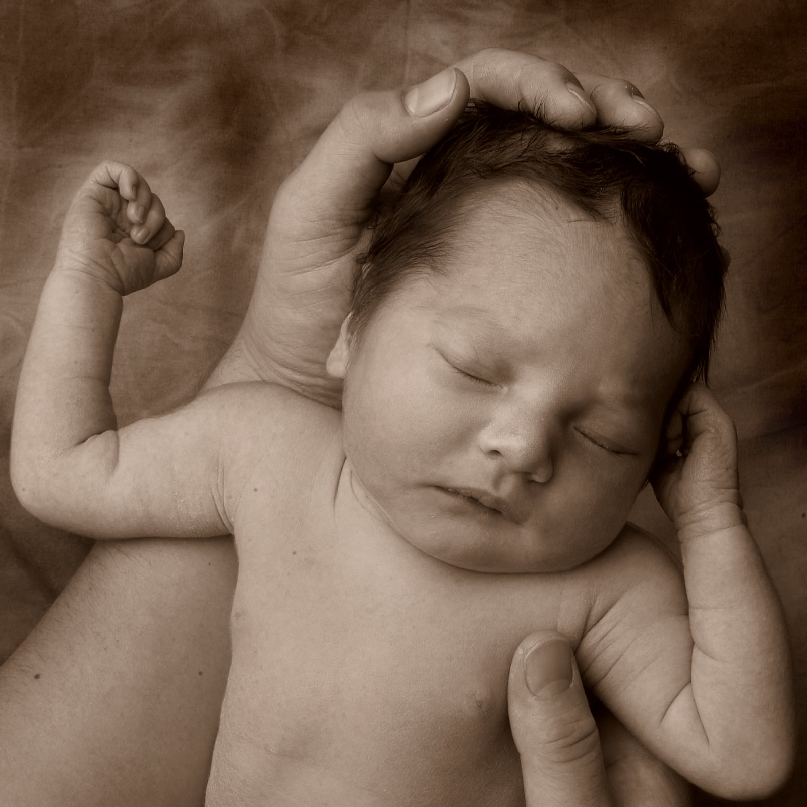 slapende pasgeboren baby in handen close up door fotograaf Alex de Smit