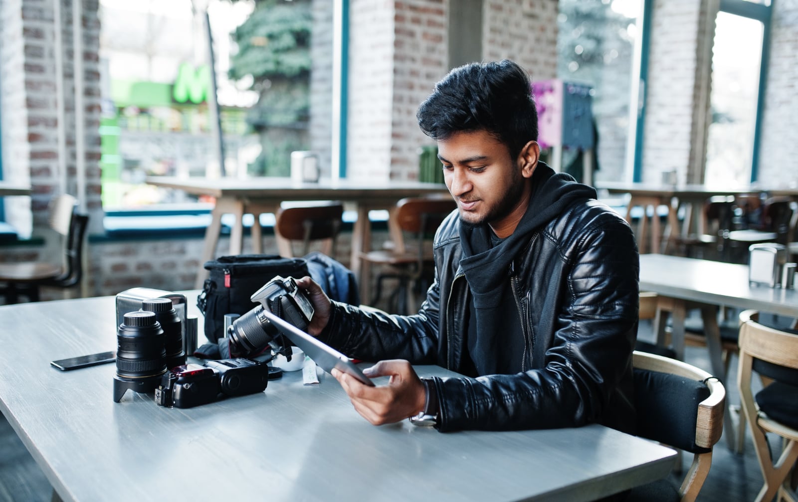 2 smart-young-asian-man-photographer-working-with-tablet-during-sitting-cafe
