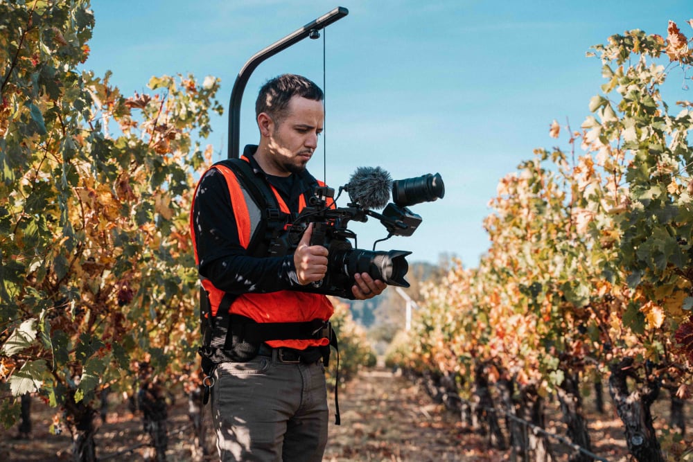 videograaf buiten in boomgaard aan het filmen
