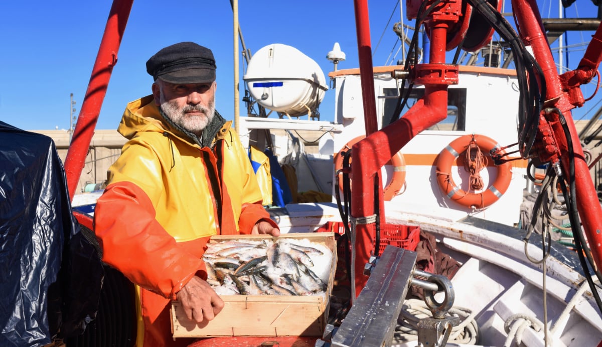 portret van visser p zijn boot in de zon