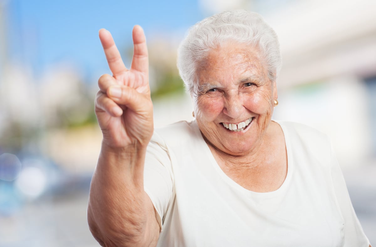 grandmother-with-two-fingers-raised-smiling