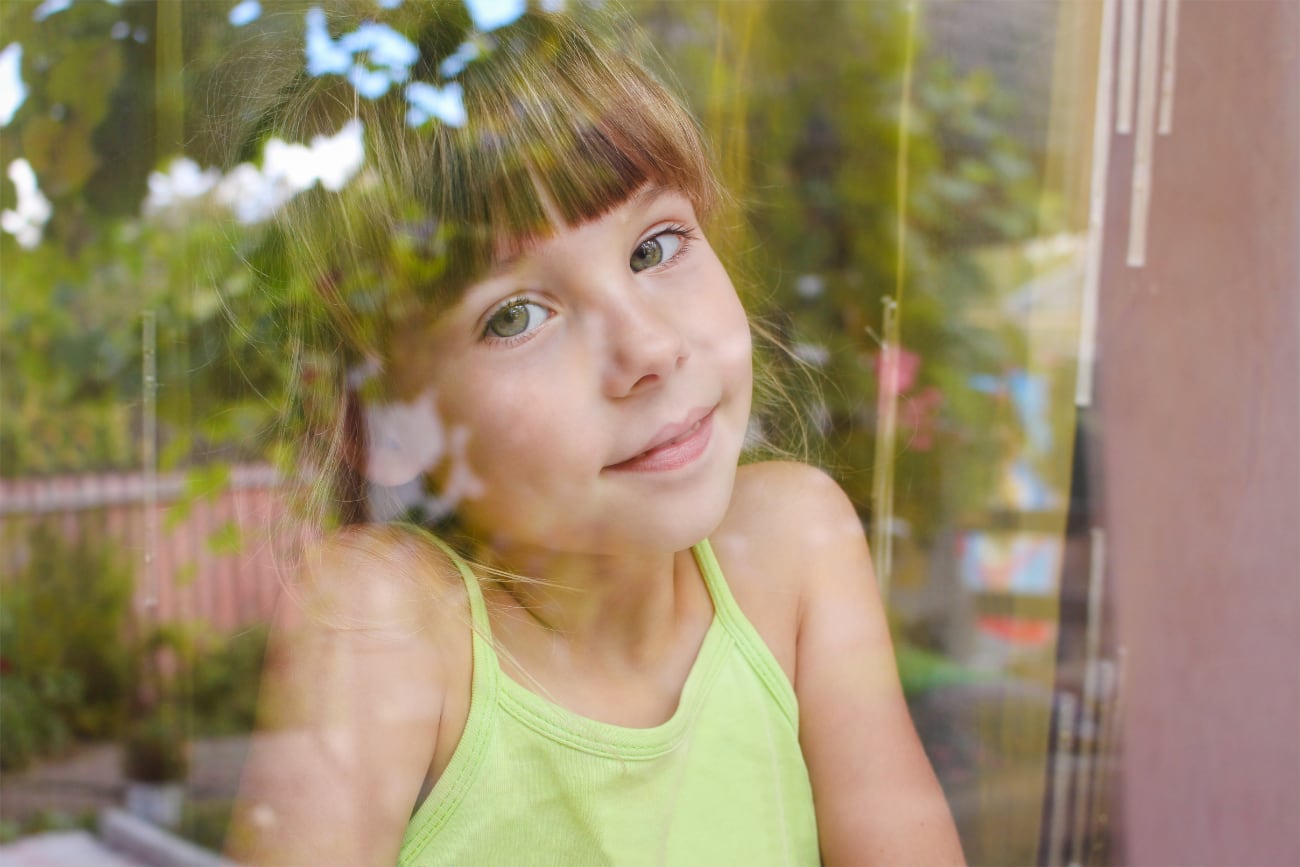 happy-little-girl-looking-out-window