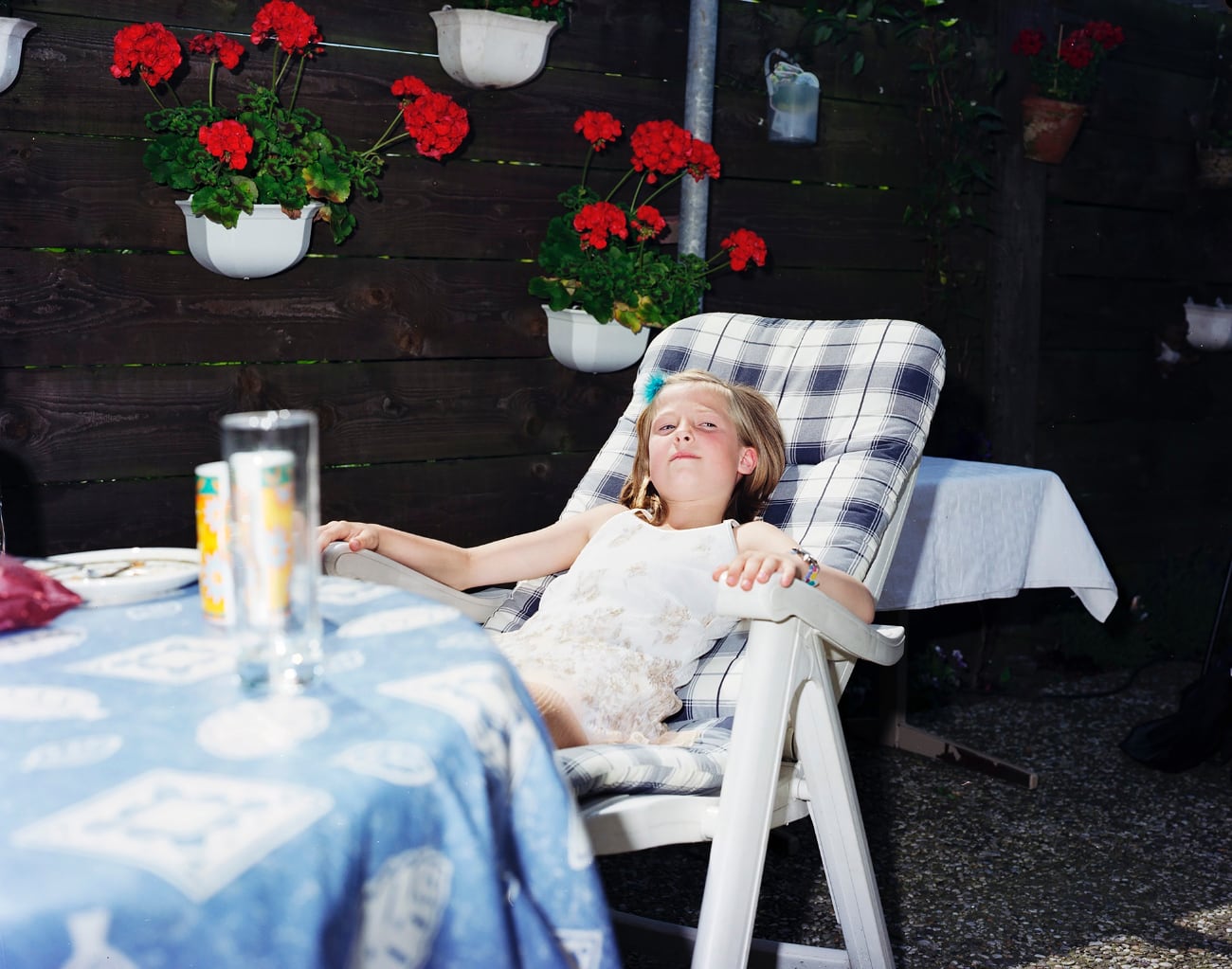 meisje in tuinstoel in tuin uit Thuis in de stad expositie van Raymond Wouda