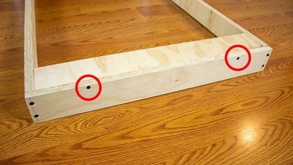 An image of a support strip held in place using wood glue and two wood screws (red).