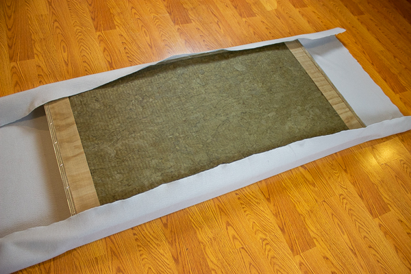 An image of an acoustic panel partially wrapped in felt using an adhesive spray.