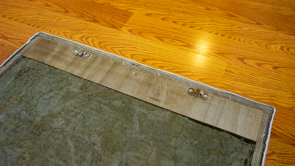 An image of flush mount brackets screwed into the back of an acoustic panel.