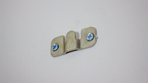 A close up view of a flush mount bracket screwed into drywall anchors.