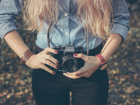 woman taking picture facing computer screen