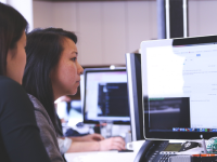 two people discussing something at workstation