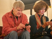 2 people in their 50's using their phones