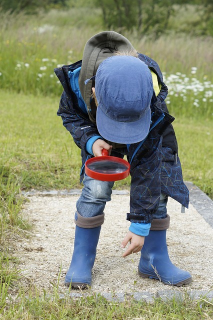 kid using magnifying glass to look at floor