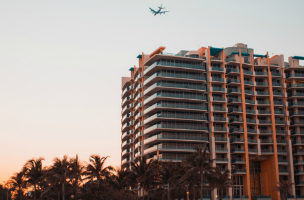 airplane flying over highrise bulding