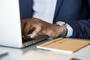 man typing on laptop wearing a nice watch