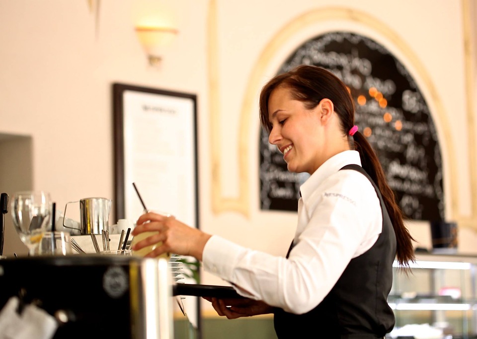waitress carrying glass in restaurant
