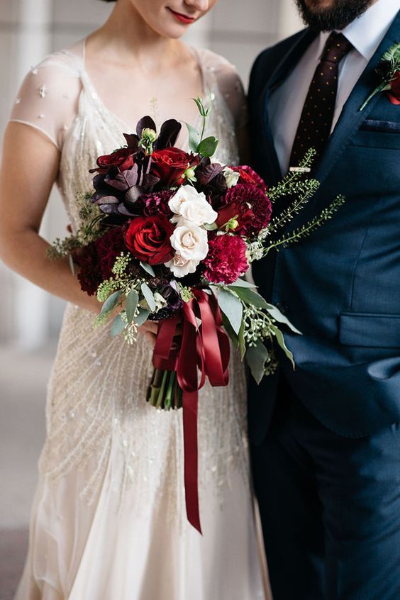 bride holding bouquet of red and white flowers
